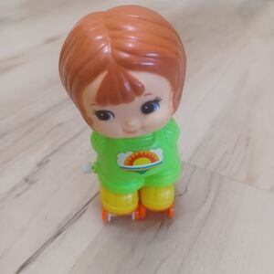Vintage wind-up skate girl. Green, yellow brown.